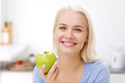 Woman smiling and holding an apple