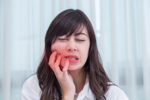 Woman holding her mouth in pain